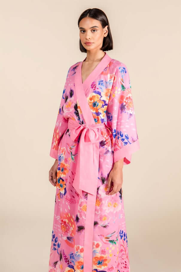 Woman wearing Cherry Blossom Cotton Robe with floral design on pink fabric.