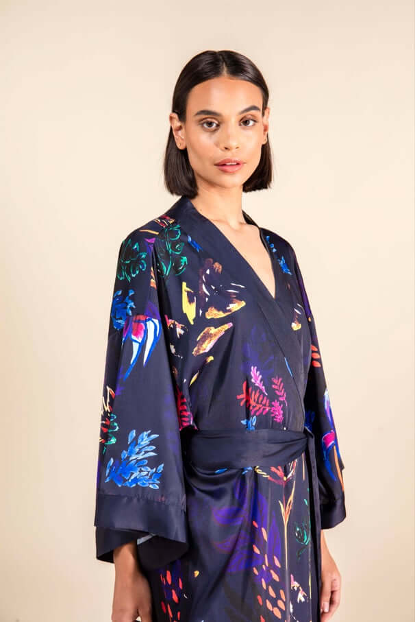 Model wearing a Chicory Silk Satin Robe with vibrant electric blue, pink, red, and orange artwork inspired by the chicory plant.