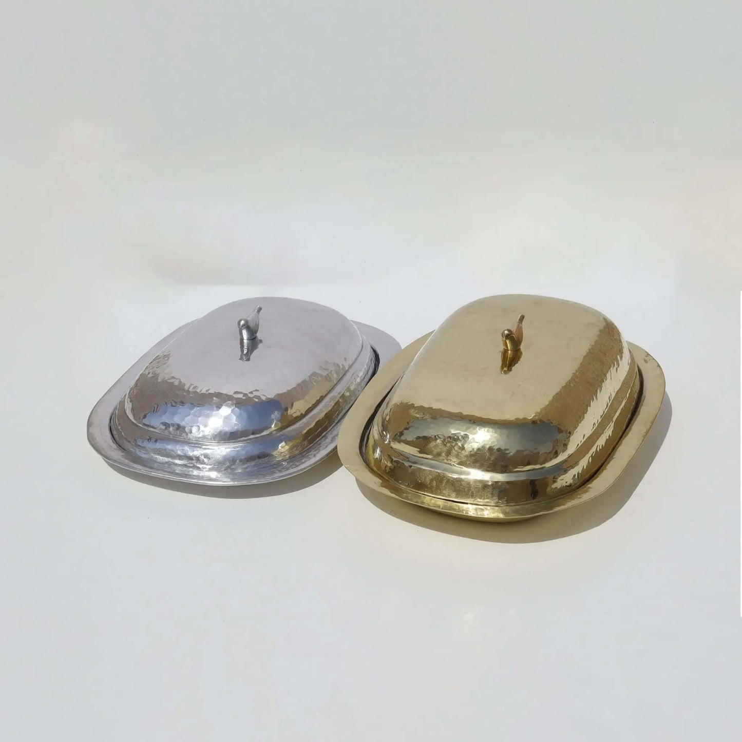 Plate With Bird Handle Cover Silver, featuring hammered aluminum with bird-shaped handles, next to a similar gold plate and cover.
