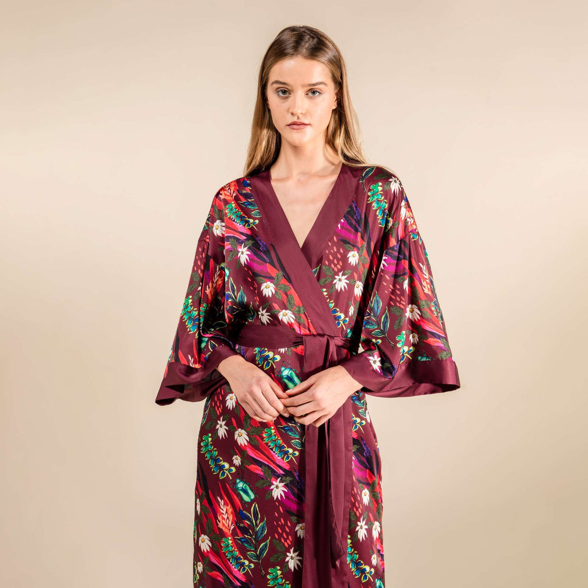 Woman wearing deep red Hibiscus Silk Satin Robe featuring floral artwork, inspired by Japanese tradition and Chinese florals.