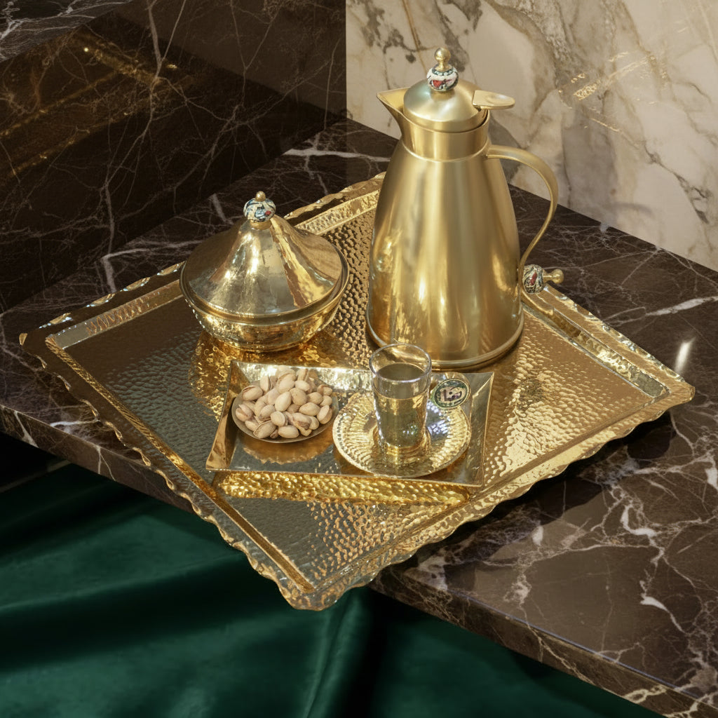 Brass zigzag tray with zigzag edges, beautifully designed with a hammered effect, showcasing pistachios and a gold coffee pot.