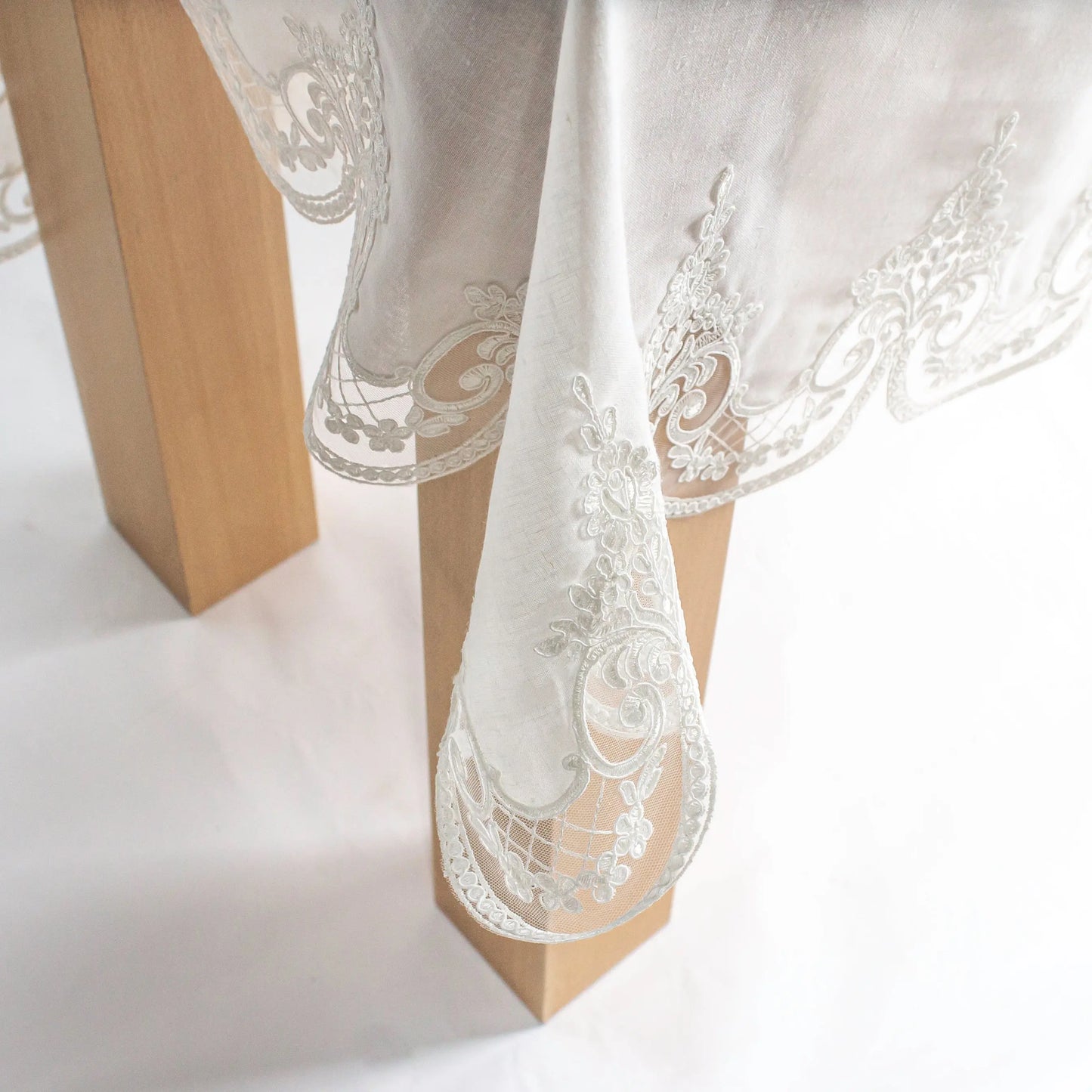 Elegant Sultan Ecru Tablecloth with intricate embroidery and cutwork on a wooden table, showcasing timeless design and refinement.